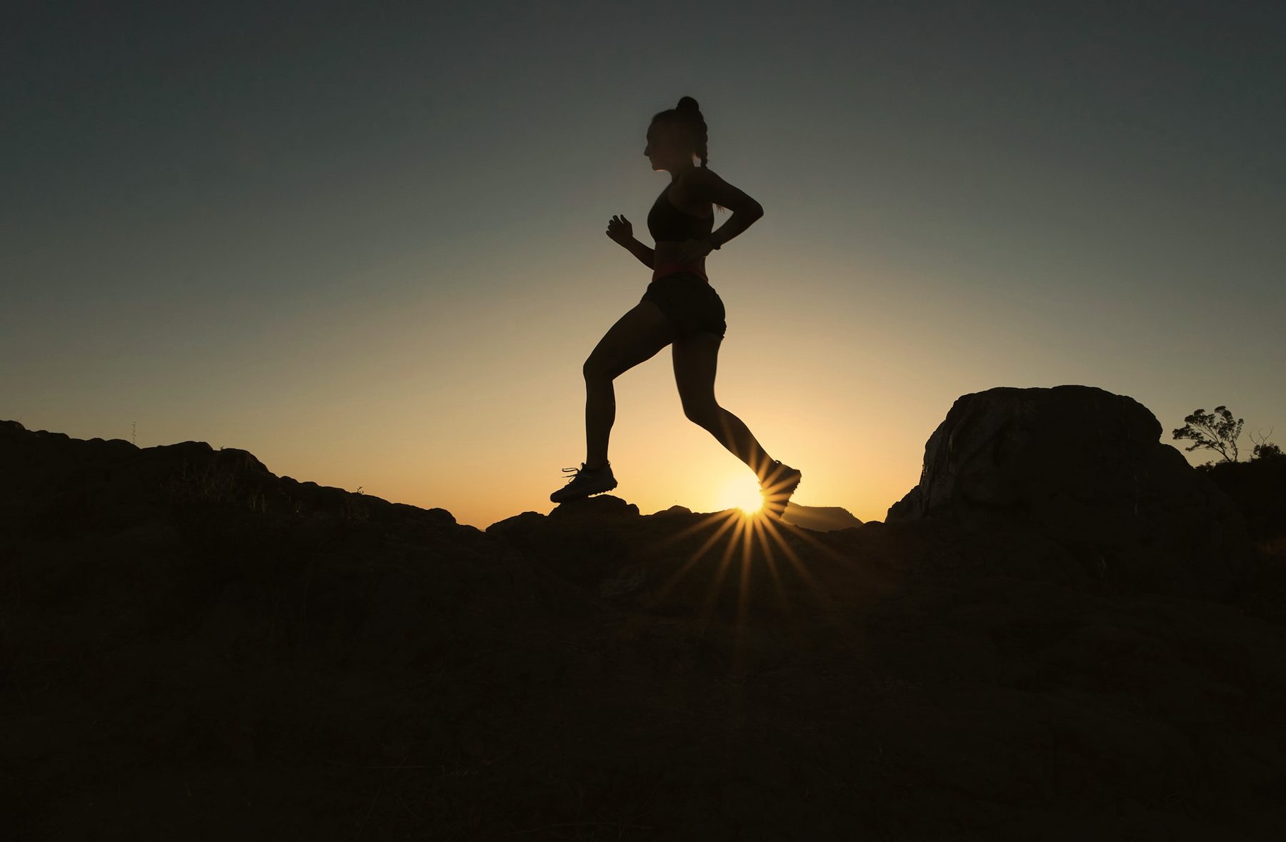 A runner in silhouette against a warm dusk sky